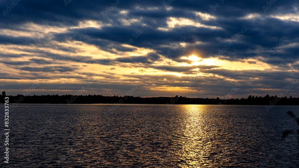 The sun sets over a vast expanse of water, creating a beautiful scene The sun sets over a vast expanse of water, creating a beautiful scene