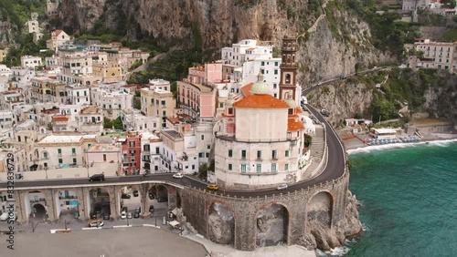 Curved coastal road leading through Atrani city with its characteristic arches and pastel colored buildings lining the route. photo