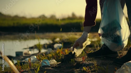 Concerned about the environment, the young man actively collects garbage and plastic waste, sorting it into bags for further recycling. He cleans the coastal area, clearing it of debris