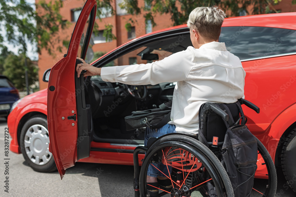 Obraz premium Female driver with disability entering a car, a wheelchair user on the way to work. Concepts of accessibility, transport, and safety.
