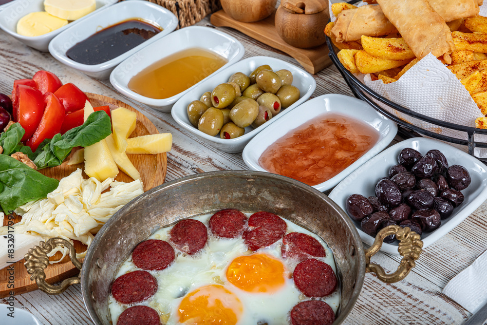 Traditional delicious modern Turkish cuisine. Plain Turkish breakfast with copper-pan egg dishes, pastries such as börek and bagels, jams, olives, cheeses, vegetables and Turkish tea. Traditional delicious modern Turkish cuisine. Plain Turkish breakfast with copper-pan egg dishes, pastries such as börek and bagels, jams, olives, cheeses, vegetables and Turkish tea.