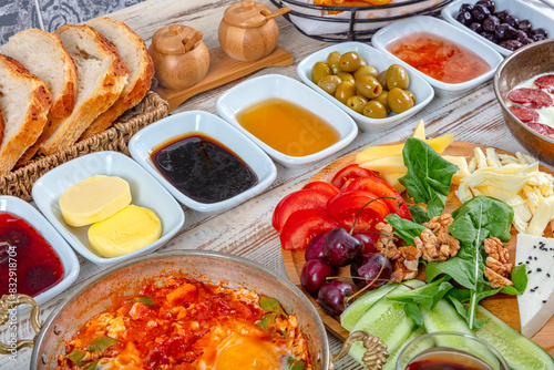 Traditional delicious modern Turkish cuisine. Plain Turkish breakfast with copper-pan egg dishes  pastries such as b  rek and bagels  jams  olives  cheeses  vegetables and Turkish tea.