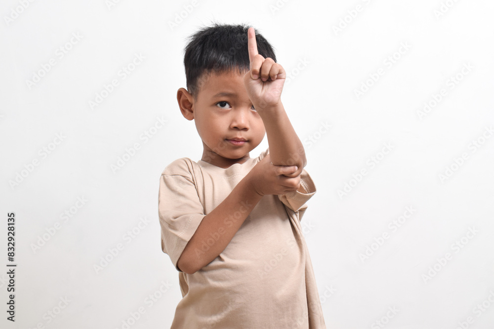 Image of Asian child posing pointing towards the front on a white background. portrait of an Asian boy Image of Asian child posing pointing towards the front on a white background. portrait of an Asian boy