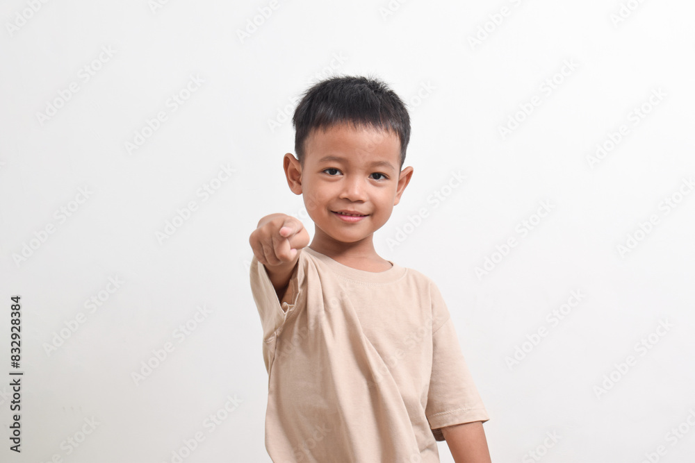Image of Asian child posing pointing towards the front on a white background. portrait of an Asian boy Image of Asian child posing pointing towards the front on a white background. portrait of an Asian boy
