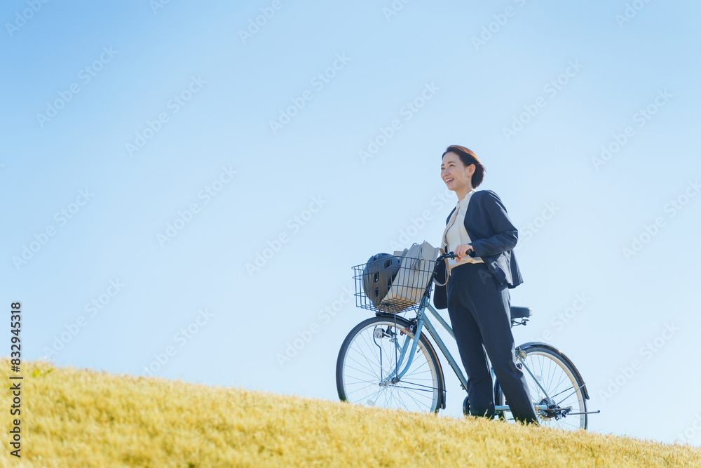 Obraz premium 青空と自転車通勤するビジネスマン