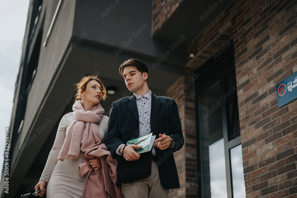 Two young entrepreneurs engaging in a strategic business meeting outside an urban building, focusing on growth and profitability. Two young entrepreneurs engaging in a strategic business meeting outside an urban building, focusing on growth and profitability.