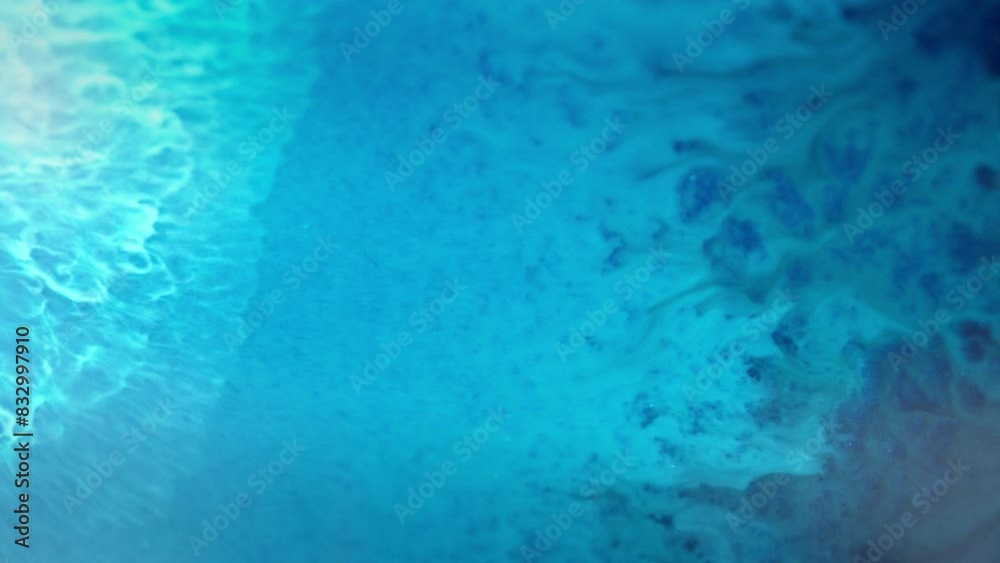 Blue ink swirling in water creates a mesmerizing abstract pattern, close-up view Blue ink swirling in water creates a mesmerizing abstract pattern, close-up view
