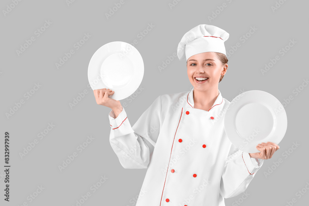 Female chef with empty plates on grey background Female chef with empty plates on grey background