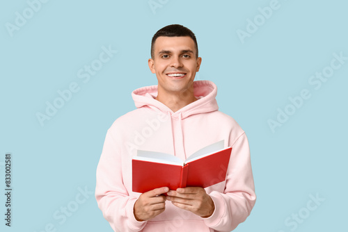 Handsome young man reading ...