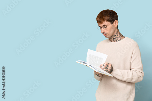Young tattooed man reading ...