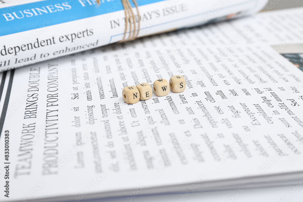 Newspapers and word NEWS made of cubes, closeup Newspapers and word NEWS made of cubes, closeup