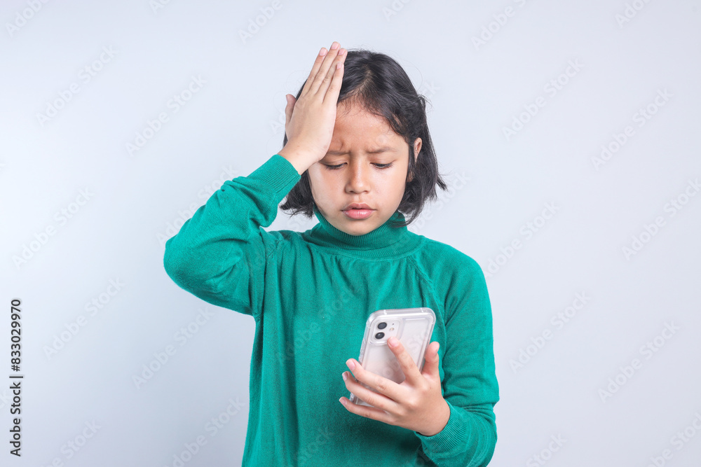Upset child girl using smartphone feeling surprised of bad news or fail education test. Upset child girl using smartphone feeling surprised of bad news or fail education test.