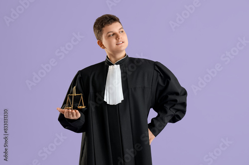 Teenage judge with justice scales on lilac background photo