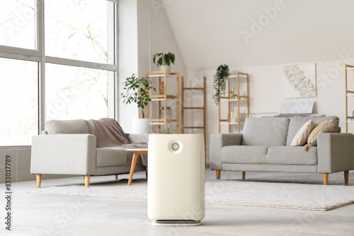 Modern humidifier and grey sofa in stylish living room