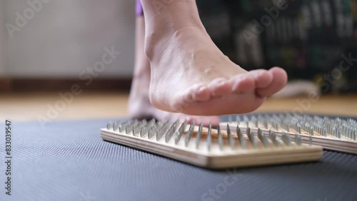SADHU boards for standing on metal nails. A woman's foot on boards with nails. A female yogi. a close-up of the leg. Yoga practice. The concept of yoga and meditation. photo