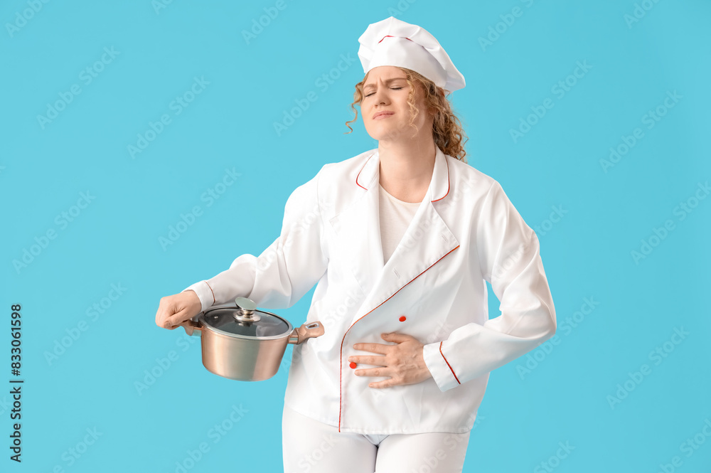 Female chef with cooking pot suffering from menstrual cramps on blue background