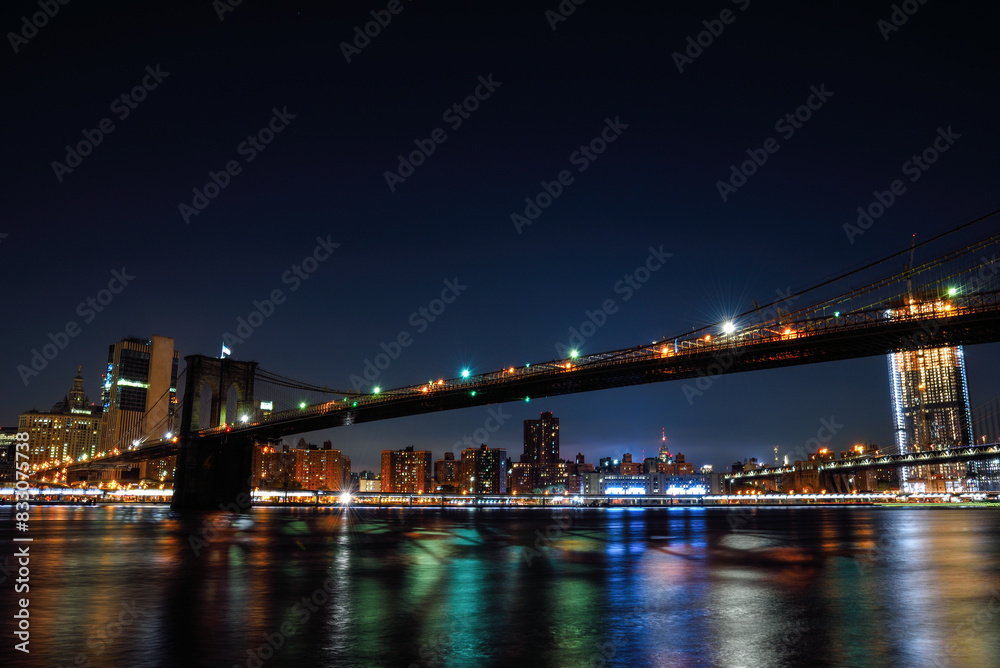 Obraz premium Night View of the Illuminated Brooklyn Bridge over the East River - Manhattan, New York City