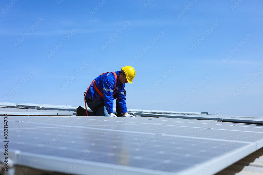 Caucasian engineer is installing solar panels on the roof of industrial factory. Caucasian engineer is installing solar panels on the roof of industrial factory.