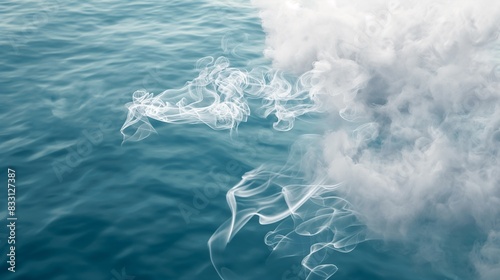 A serene and peaceful image of white smoke floating in blue water, evoking the calm and soothing aspects of the oceana??s surface. photo