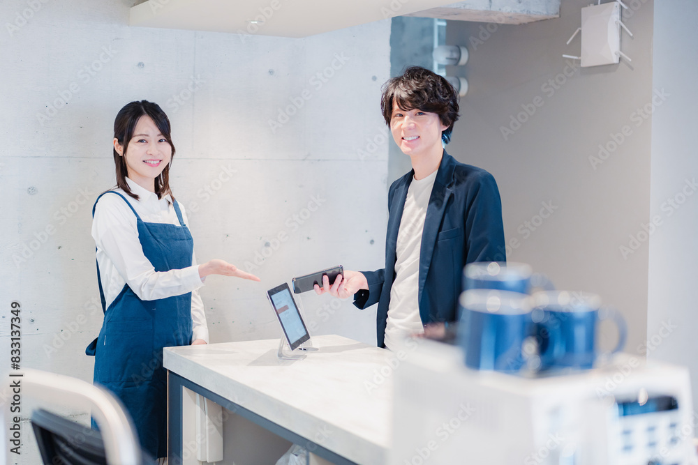 カフェでクレジットカード決済をする男性 カフェでクレジットカード決済をする男性