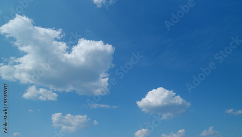 Summer blue sky with fluffy white clouds. White clouds float across the blue sky. Timelapse.