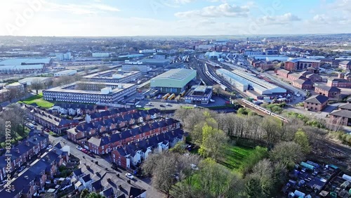 On a bright and sunny day, an aerial shot of a running train is made from above. Derby Etches Park - a train depot - is seen from above together with Siemens Automation corporate office   photo