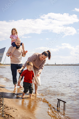 Portrait of a family of four on the beach in spring