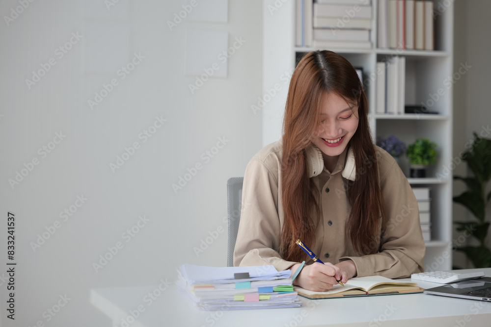 Young woman working indoor and using laptop, headset with happy and smile face. Young woman working indoor and using laptop, headset with happy and smile face.