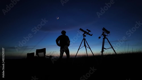 Amateur astronomer looking at the evening skies, observing planets, stars, Moon and other celestial objects with a telescope and camera on a star tracker.	
 photo