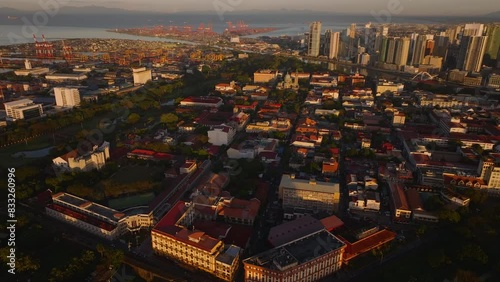 Manila's cituscape in the Philippines at sunset. Vibrant urban architecture, bustling metropolis and the port from above photo