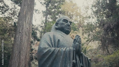 Buddhist Statue In The Forest Of Mitaki In Hiroshima, Japan. closeup, low angle shot photo