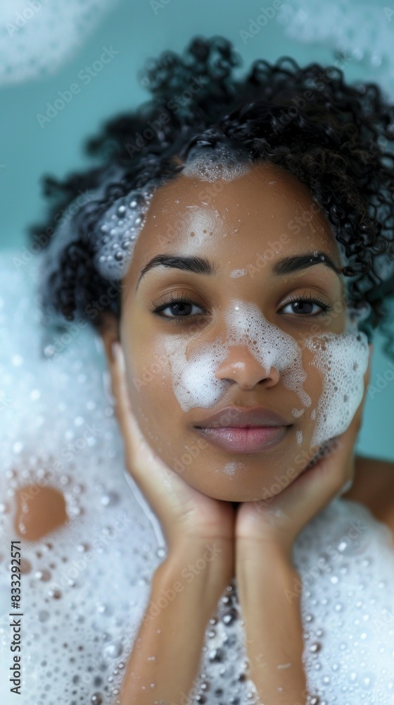 A woman is in a bathtub with bubbles and foam on her face