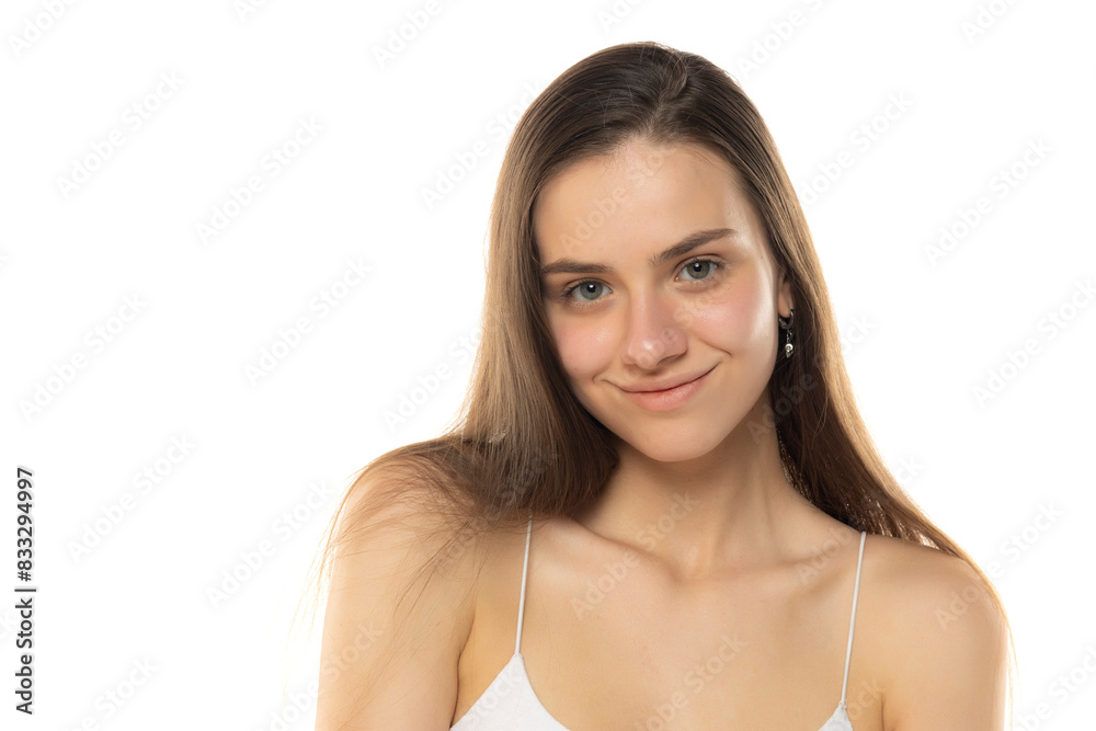 portrait of a young smiling teenage girl without makeup on a white background