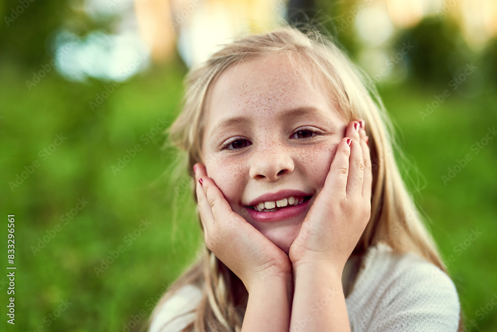 Fototapeta premium Girl, child and smile on grass with portrait outdoor for fun or playing, fresh air and enjoyment of youth or childhood in summer. Female kid, relax and nature in afternoon for carefree and adventure.