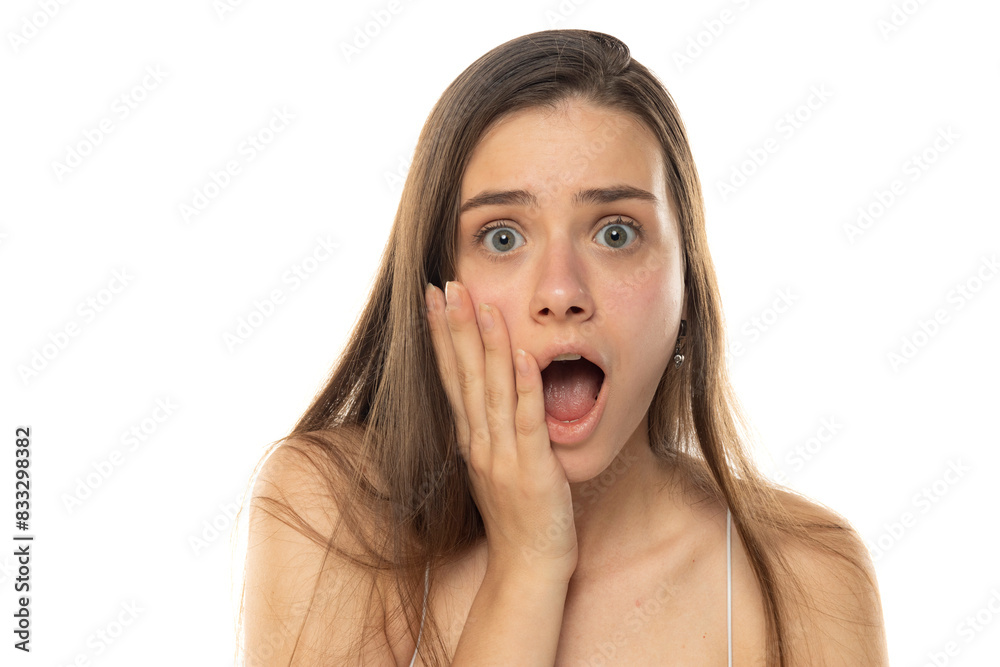 portrait of a young shocked teenage girl without makeup on a white background portrait of a young shocked teenage girl without makeup on a white background