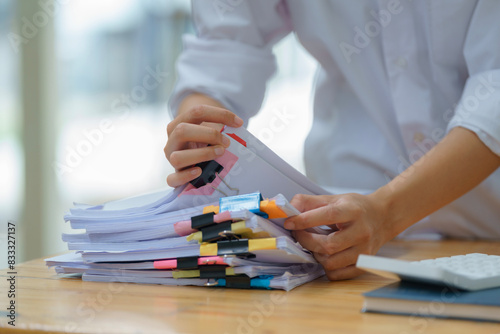 Close-up hand of Asian businesswoman arranging documents on her desk.