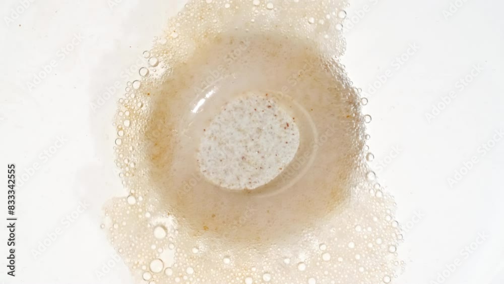Close-up Effervescent tablet aspirin, vitamins on a white background. Macro shot of fine air bubbles in water in a petri dish. The medicine concept, health care, treatment. Slow motion. 4k Close-up Effervescent tablet aspirin, vitamins on a white background. Macro shot of fine air bubbles in water in a petri dish. The medicine concept, health care, treatment. Slow motion. 4k