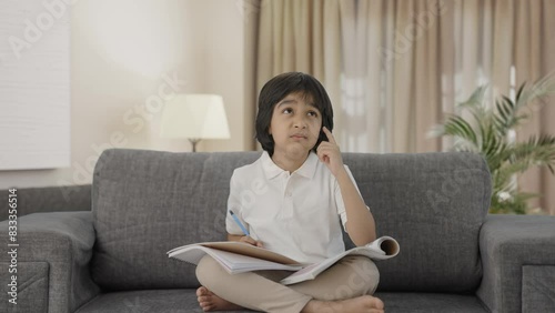 Confused Indian boy reading and studying