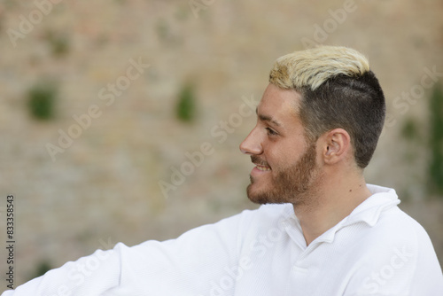 Smiling young man with trendy hairstyle outdoors photo