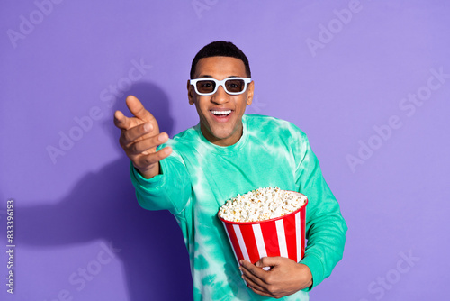 Photo of cheerful positive guy dressed turquoise sweatshirt watching vr movie enjoy pop corn isolated violet color background.