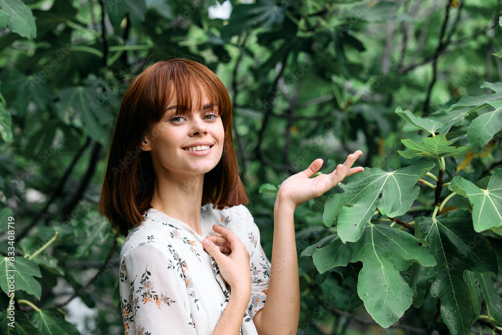 serene redhead woman standing by lush green tree in nature serene redhead woman standing by lush green tree in nature