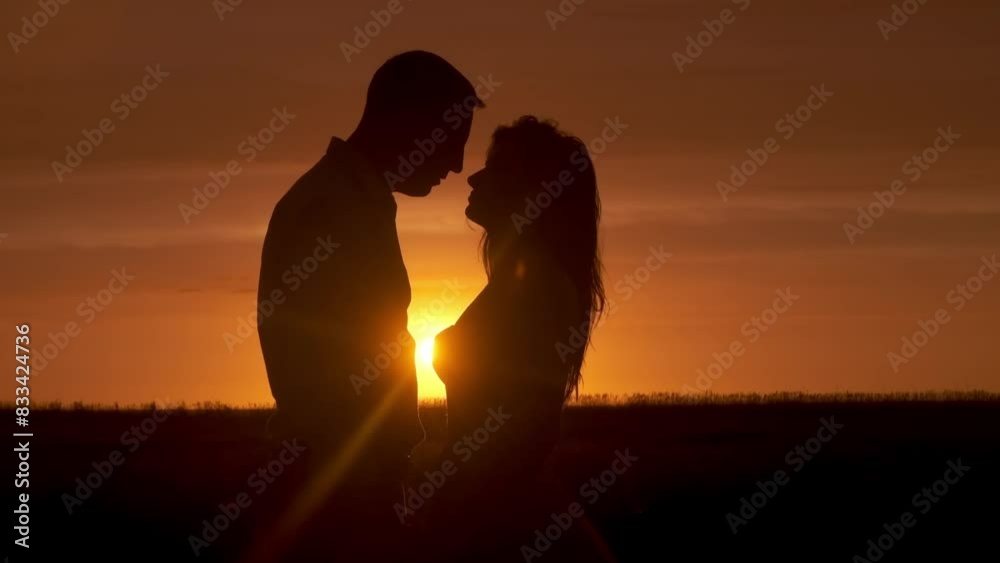 Silhouette of a couple in love in glamor romance at sunset. Love story concept.