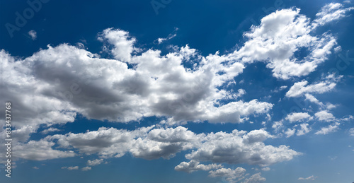 Fluffy cumulus clouds on blue sky background. Cloudscape