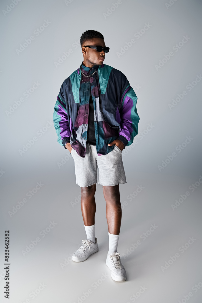 Stylish African American man in colorful jacket and shorts posing confidently. Stylish African American man in colorful jacket and shorts posing confidently.