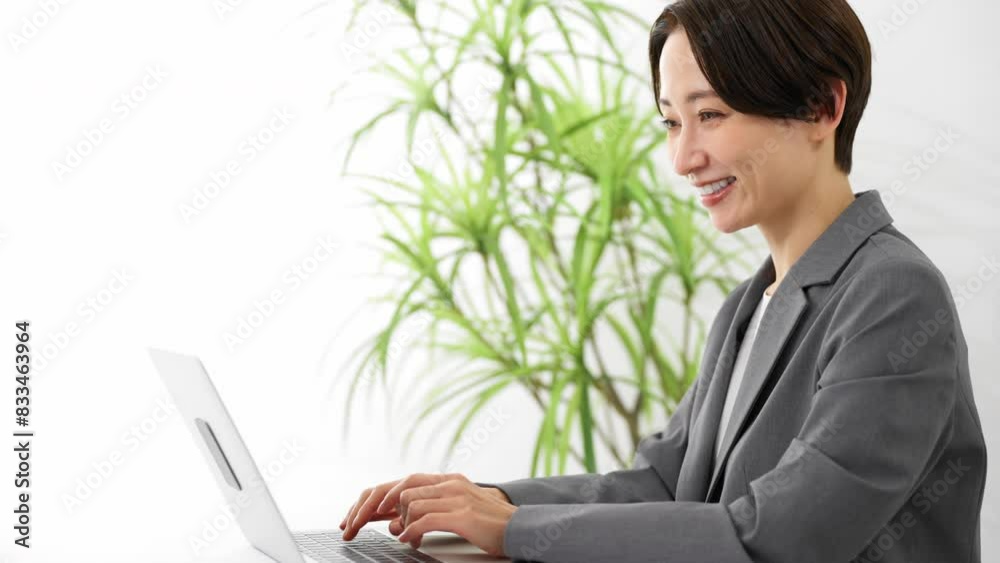 ビジネススーツを着てラップトップを操作している若い女性 ビジネスイメージ ビジネススーツを着てラップトップを操作している若い女性 ビジネスイメージ