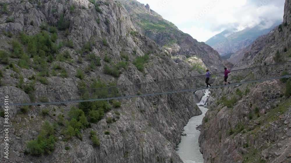 Aerial drone view of two tourists on Oberaletsch and Aletsch glacier with suspension bridge Belalp-Riederalp Switzerland Aerial drone view of two tourists on Oberaletsch and Aletsch glacier with suspension bridge Belalp-Riederalp Switzerland