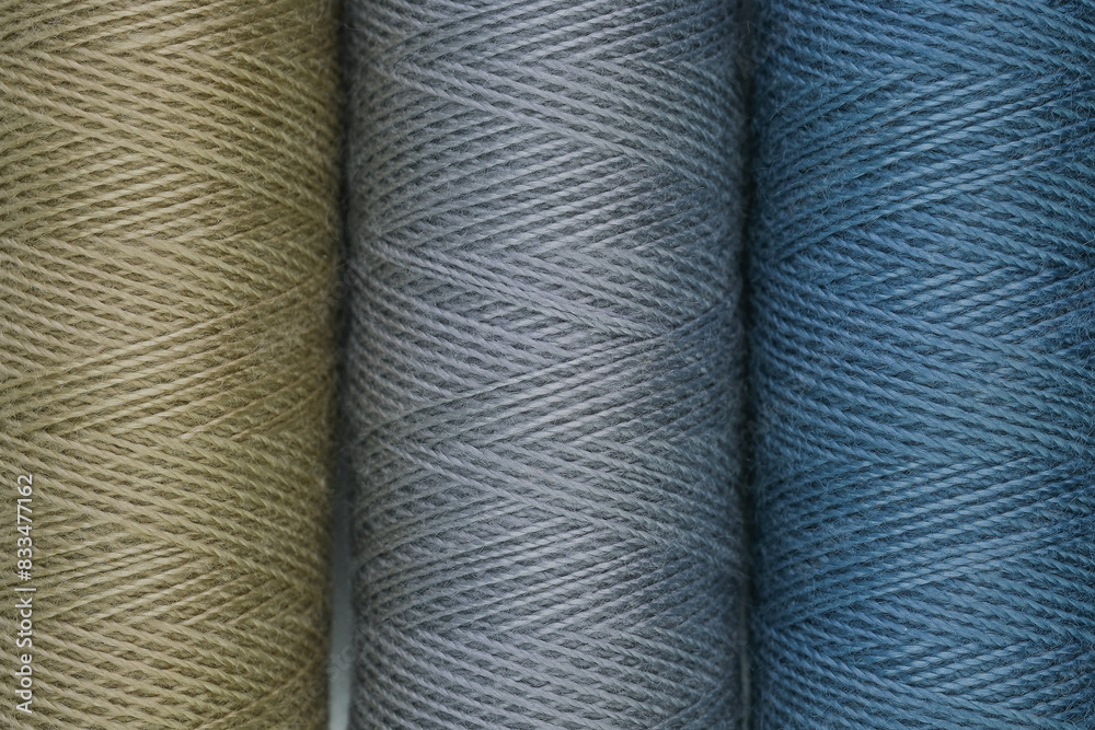 Spools of thread in different colors arranged on a surface, close up Spools of thread in different colors arranged on a surface, close up