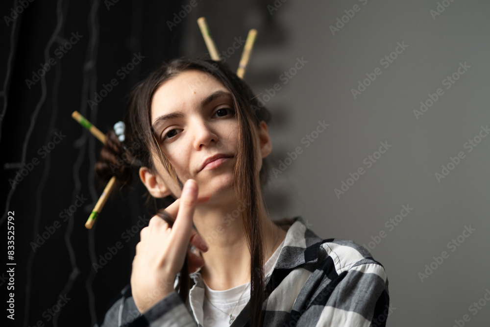 Obraz premium Stylish Young Girl With Artistic Hairstyle and chopsticks in asian style Posing for a Casual Portrait