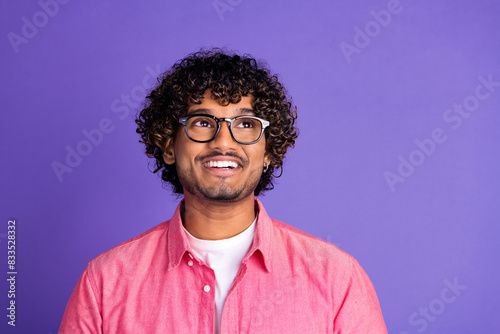 Photo of nice young man look empty space wear pink shirt isolated on violet color background
