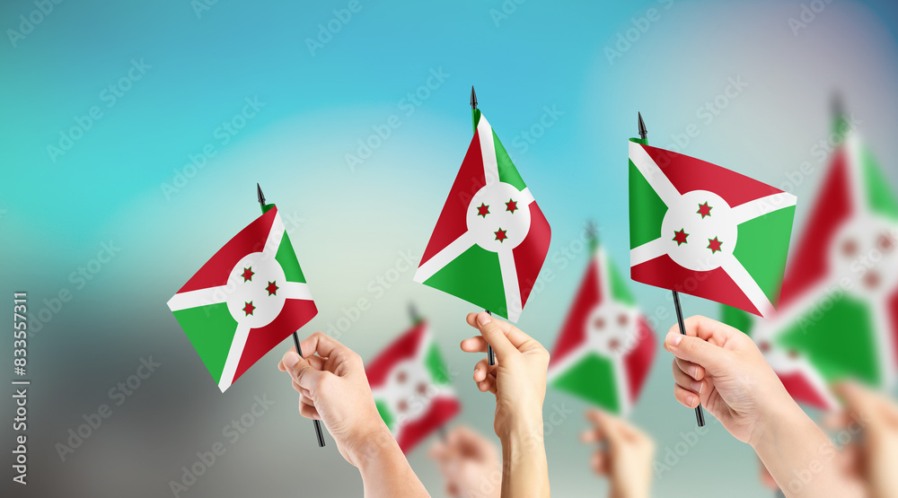 Fototapeta premium A group of people are holding small flags of Burundi in their hands.